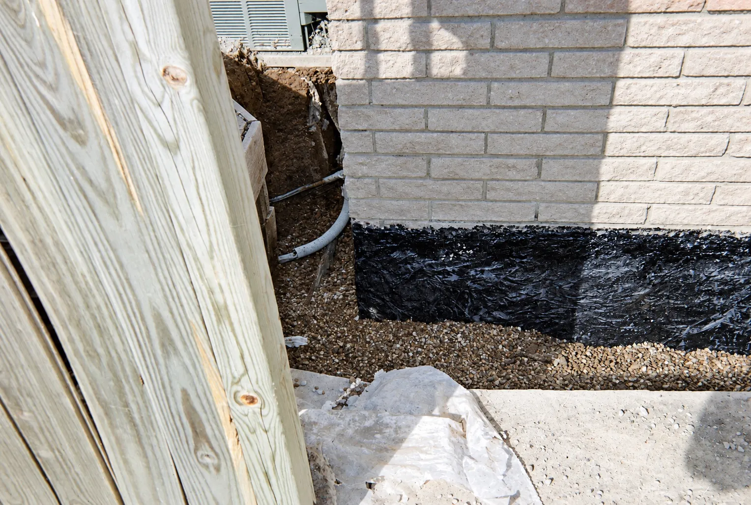 Fresh tar coating on a foundation wall below grade