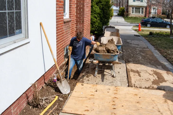 Plywood laid over the lawn and walkway to protect them during hand excavation