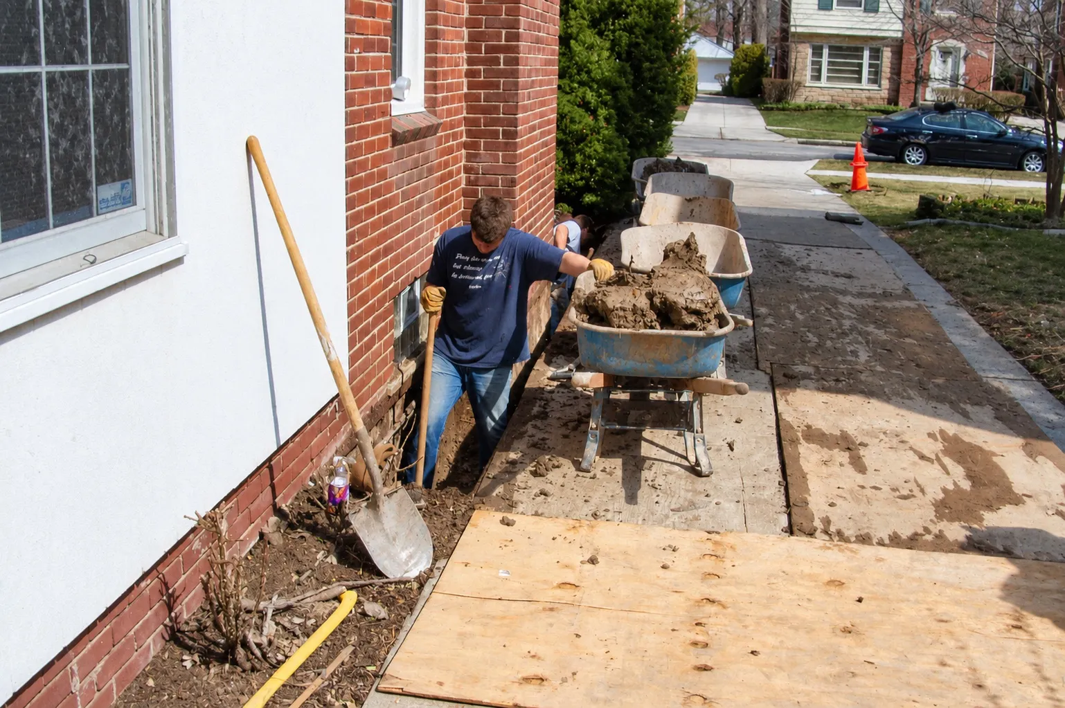 Plywood laid over the lawn and walkway to protect them during hand excavation